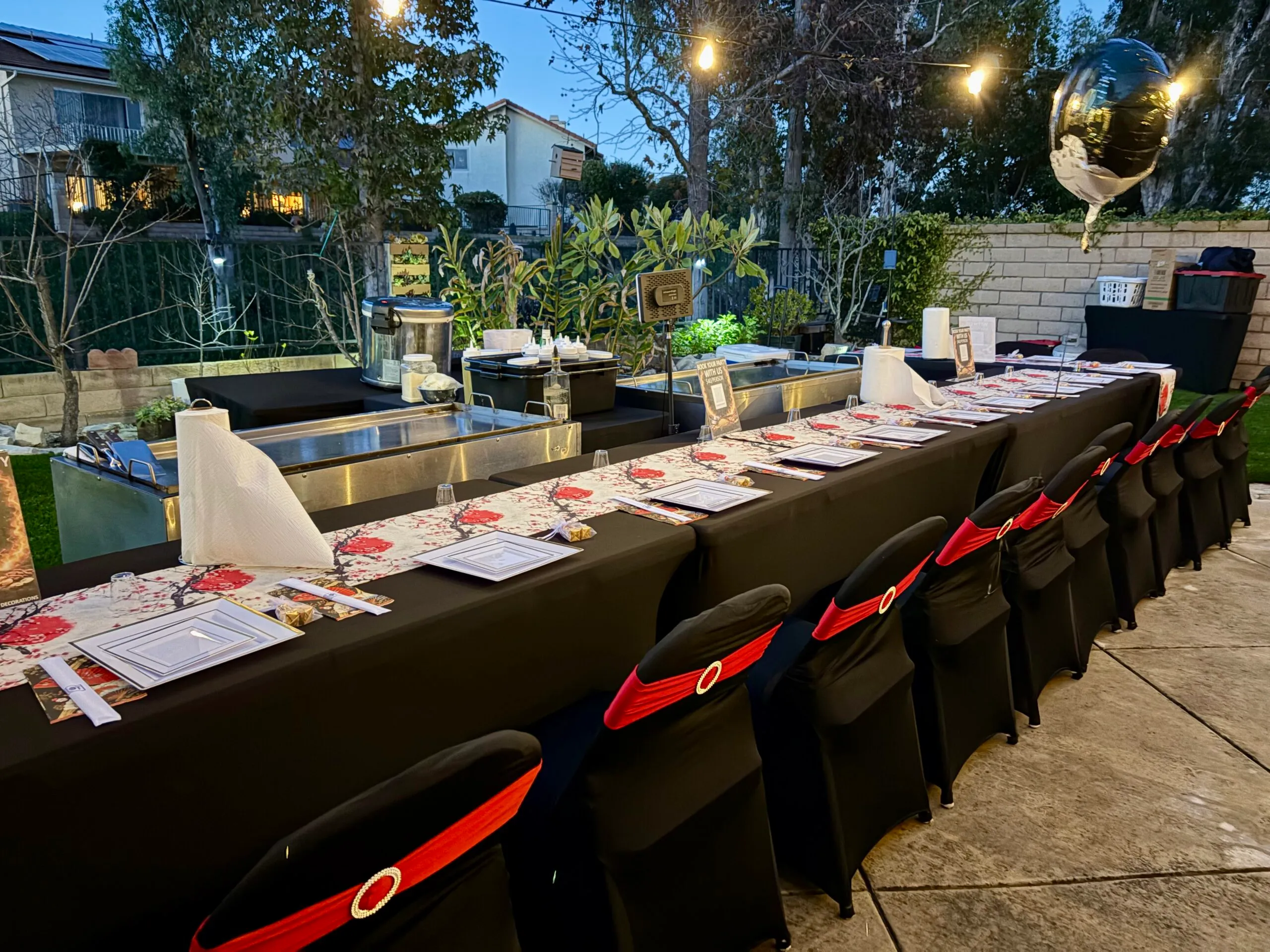 Guests seated around a private teppan grill during a Teppan Party backyard dinner